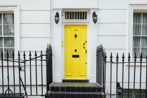 Paint your front door for curb appeal. A bright yellow door on a white clapboard house adds a pop of colour.